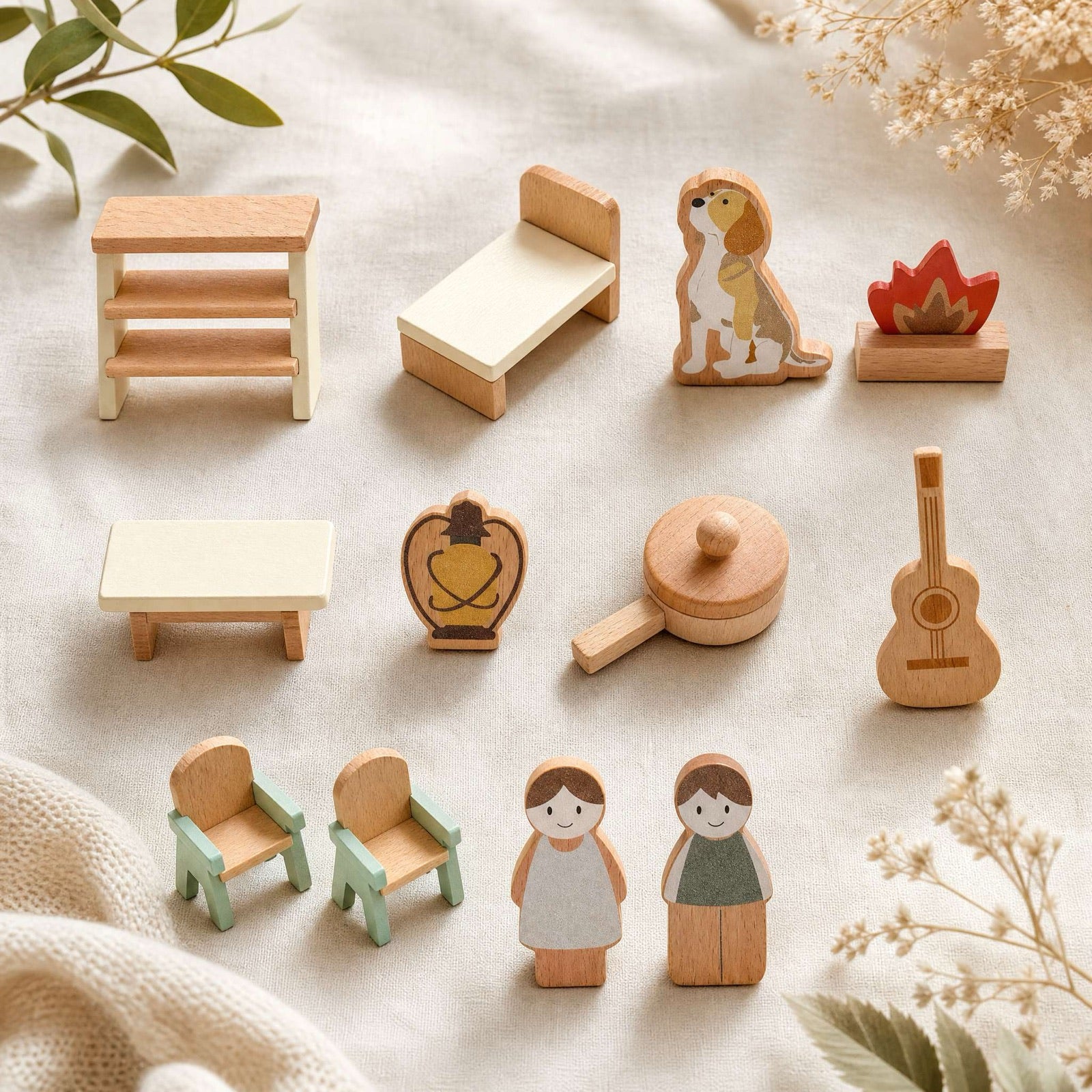 Wooden toys and small figures arranged on linen