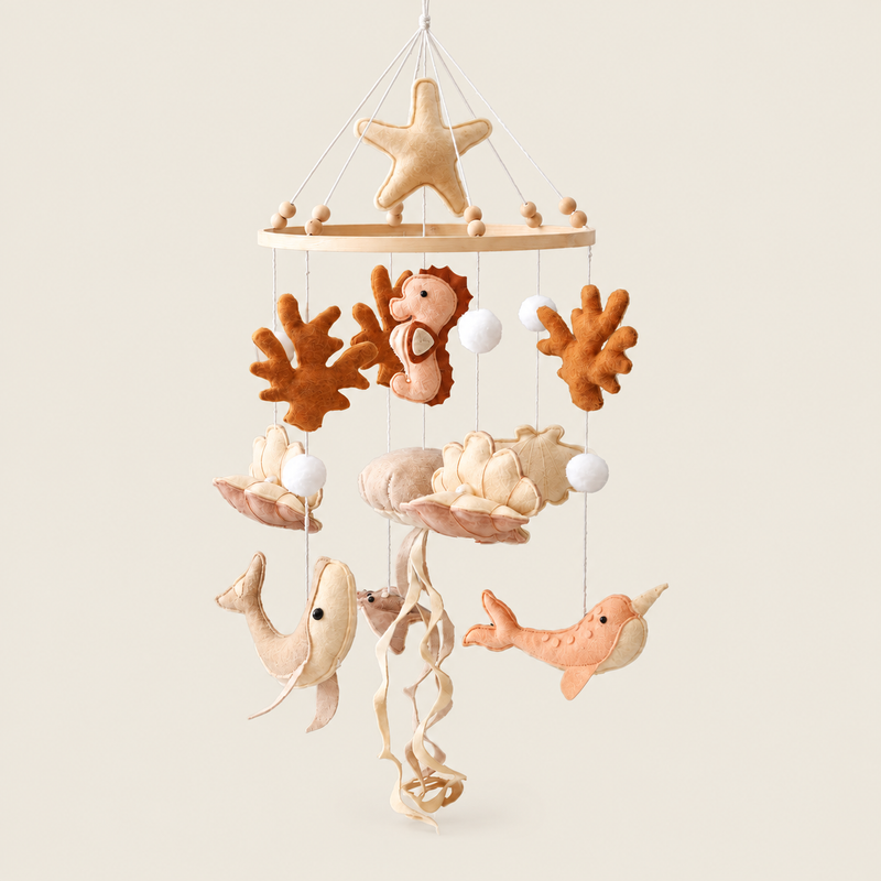 Crib mobile with hanging rattles on warm ivory background